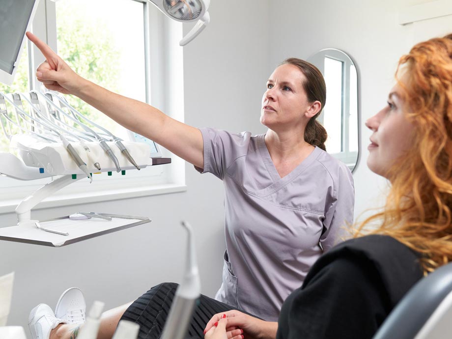 Zahnärztin berät Patientin über eine möglichen Behandlung.